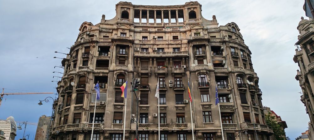 Historisk facade i Bukarest med adskillige klimaanlæg og EU-flag